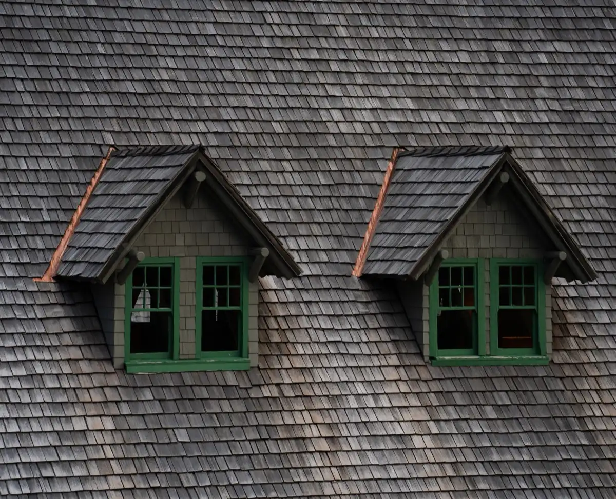 Dormers on a shingle roof in Manchester, NH, where step flashing and kickout flashing carry water past the walls